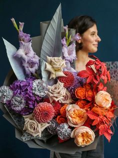 a woman holding a bouquet of flowers in her hands