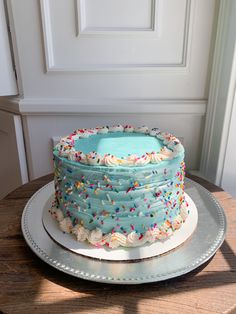 a cake with frosting and sprinkles sitting on top of a table