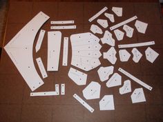 cut out pieces of white paper sitting on top of a brown mat with holes in them