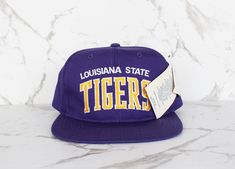 🐯 Vintage LSU Tigers Snapback Hat 🧢 90s Starter Arch Baseball Cap 🧢 One size fits most 👌 Deadstock 1990s hat in perfect condition with original tags Throwback College Cap, College Snapback Cap, College Snapback Hat One Size Fits Most, College Snapback Hat, Vintage Visor Hat For Streetwear, Vintage Adjustable Dad Hat For Sports, Adjustable Throwback Hats For College, Adjustable Vintage Dad Hat For Sports, Vintage Baseball Cap For College