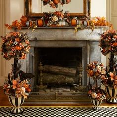 a fireplace decorated with pumpkins and flowers in front of a mirror on the wall