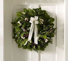 a wreath hanging on the front door of a house