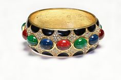 Vintage Ciner Bracelet.Indulge in luxury with our exclusive Vintage Ciner Mughal Style Bangle Bracelet. Adorned with vibrant red, blue, and green cabochon glass and enamel, this bracelet exudes sophistication and artistry. Elevate any outfit with this unique and timeless piece. Approximate Measurements: best suitable for a small wrist. Luxury Multicolor Cabochon Bracelet, Designer Enamel Bangle Jewelry, Luxury Multicolor Enamel Jewelry, Elegant Enamel Bangle For Formal Occasions, Elegant Formal Enamel Bangle, Luxury Multicolor Bangle For Formal Occasions, Formal Enamel Bangle, Elegant Red Enamel Bracelets, Party Jewelry With Jeweled Enamel