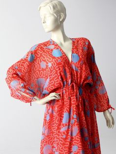 "1970s A rare find! This vintage dress was from an early Zandra Rhodes collection. The airy, faux chiffon red dress features a blue and pink seashell print. Bat wing sleeves and a full skirt add to the dramatic flair of the maxi dress. The elasticized waist is detailed with a decorative bow tie. ○ Airy, faux silk chiffon (polyester) dress ○ Bold red dress with a sky blue and pink seashell print. ○ Bat wing sleeves with keyhole tie sleeve ends ○ Elasticized empire waist with a decorative bow tie Red Long Sleeve Dress For Beach Cover-up, Red Long Sleeve Maxi Dress For Beach Cover-up, Red Kimono Sleeve Beach Dress, Red Printed Maxi Dress For Beach, Red Beachwear Dress With Kimono Sleeves, Red Flowy Beach Cover-up Dress, Red Flowy Dress For Beach Cover-up, Vintage Flowy Printed Maxi Dress, Red Dress With Kimono Sleeves For Party