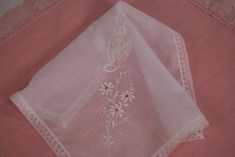 "Lovely vintage hanky made in Switzerland: * White daisies and butterfly embroidery on white hanky * Beautiful cutwork * The perfect \"something old\" wedding accessory * New with tag: All Cotton Made in Switzerland  * 10 1/2\" x 10 1/2\" * Estate sale find from a smoke free home * No holes, stains or tears * Excellent vintage condition * PN 1104 This would be a lovely wedding accessory for the bride, bridesmaid, mother of the bride or groom, or grandmother of the bride or groom! New Old Stock (NOS) vintage treasures, with or without tags, are sold \"as found\".  I do not launder them so as to retain their \"newness\".   These items sometimes have spots or light yellowing from decades of storage, especially along fold lines.  A gentle soak and laundering usually washes the yellowing right Formal White Embroidered Handkerchiefs, Vintage Floral Embroidery Wedding Handkerchiefs, Vintage Wedding Handkerchiefs With Machine Embroidery, Elegant White Floral Embroidered Handkerchiefs, Elegant White Handkerchiefs With Floral Embroidery, Classic White Lace Handkerchiefs, Classic White Lace Handkerchief, Elegant White Handkerchiefs With Machine Embroidery, Classic White Lace Work Handkerchiefs