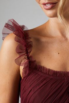 a woman wearing a red dress with ruffles on it