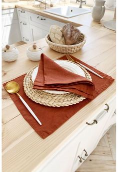 a wooden table topped with plates and bowls filled with food next to a bowl full of bread