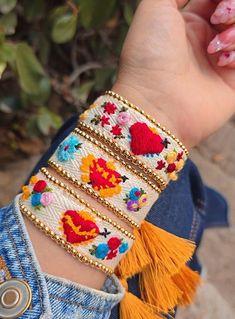 a woman's arm with colorful bracelets on it