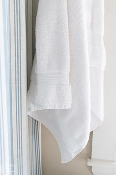 two white towels hanging on a towel rack