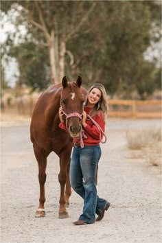 a woman is standing next to a brown horse