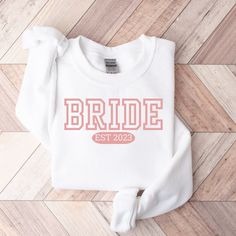 "Bride Sweatshirt, Future Mrs Hoodie, White Bride Hoodie, New Mrs Sweatshirt, Bride Crewneck, Custom Date Hoodie,Custom Mrs Sweatshirt 🕊 Thanks for choosing us. You are welcome to our Store. Our Bride Sweatshirt, Bride T-shirt are made with love and devotion. Whether you're looking for a unique wedding gift for a loved one or something special for yourself, our products are perfect. Shop Now for a unique blend of fashion. 🛍️ 🌟 How To Order- 1. Select the Colour you want. 2. Choose the Size. 3 White Hoodie Sweatshirt With Letter Print, White Fleece Hoodie With Crew Neck, White Long Sleeve Hoodie With Lettering, White Letter Print Hoodie Sweats, White Hooded Letter Print Sweats, White Varsity T-shirt For Winter, White Hooded Sweats With Letter Print, White Fleece Sweatshirt With Letter Print, White Varsity Sweatshirt For Winter