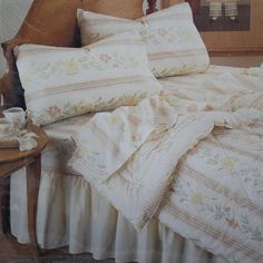 an image of a bed with pillows and blankets on it