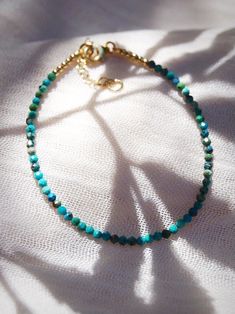 "A dainty jewelry design for appeasing the star within, this adjustable gold-filled bracelet comes beaded with tiny beads carved from all natural turquoise gemstone. ✦ DETAILS ✦ ✧ Name: Kalilinoe (kah lee lee noh eh) - rain. ✧ Adjustable Length from: 6.5\"-8\". ✧ Genuine 2.5mm faceted tiny Turquoise Beads. ✧ 14kt Gold Filled Components, Extender, and Clasp. ✧ All Ke Aloha Jewelry pieces come packaged thoughtfully, beautifully, and ready for gift giving. ✦ MORE GOLD BRACELETS ➤ https://www.etsy.c Hawaii Jewelry, Tiny Beads, Turquoise Bead Bracelet, Dainty Bracelets, Layered Bracelets, Natural Turquoise, Dainty Jewelry, Turquoise Gemstone, Turquoise Beads