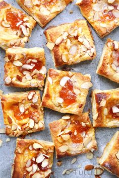 several square pieces of bread with almonds on top