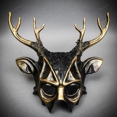 Mystery And Allure With Our Antler Deer Textured Horn With Brushed Gold Laces Devil Halloween Masquerade Mask In Black. Perfect For Anyone Seeking An Unforgettable Halloween Costume Or Masquerade Accessory, This Mask Combines The Wild Elegance Of Antler Deer Horns With The Mysterious Charm Of A Masquerade. Crafted From Durable Plastic, The Mask Features A Textured Design That Mimics The Aged Look Of Antique Artifacts, Painted In A Popcorn Textured Black To Enhance Its Appeal. Measuring Approxima Steampunk Black Masquerade Mask For Halloween, Gothic Horned Masquerade Mask For Costume Party, Black Steampunk Masks For Costume Party, Black Steampunk Party Masks, Fantasy Horned Masks And Prosthetics For Party, Horned Fantasy Masquerade Mask For Halloween, Horned Masks And Prosthetics For Halloween Party, Black Steampunk Masquerade Mask, Steampunk Black Masks And Prosthetics For Carnival