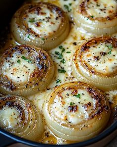 some onion rings are cooking in a pot with cheese sauce on top and parsley sprinkled around them