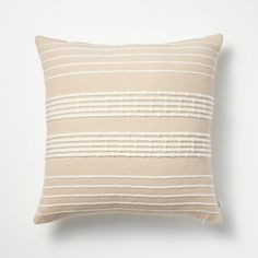 a beige and white striped pillow on a white wall