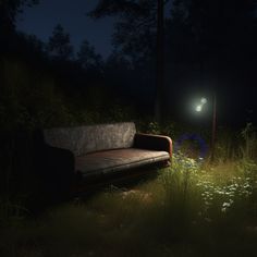 a couch sitting in the middle of a field at night with a street light shining on it