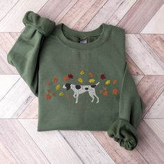 These unisex cozy sweatshirts (we use Gildan) are embroidered with a German Shorthaired Pointer surrounded by fall leaves :)  * 50% cotton, 50% polyester * Pre-shrunk * Classic fit * 1x1 athletic rib knit collar with spandex * Air-jet spun yarn with a soft feel and reduced pilling * Double-needle stitched collar, shoulders, armholes, cuffs, and hem SIZING: Please ensure you check measurement chart before ordering as shirts are printed once you place your order. Sweatshirts are unisex sizes but t Green Fleece Sweatshirt For Fall, Embroidered Green Sweatshirt For Fall, Fall Crew Neck Sweater With Custom Embroidery, Embroidered Fleece Sweatshirt For Fall, Shorthaired Pointer, Sweater Autumn, German Shorthaired Pointer, Measurement Chart, Fall Sweatshirt