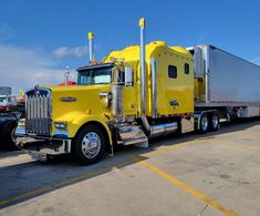 a yellow semi truck parked in a parking lot