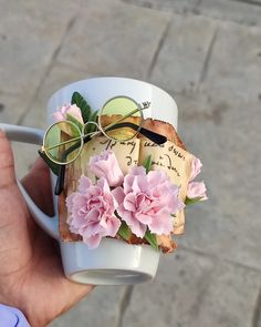 a person holding a coffee cup with flowers on it