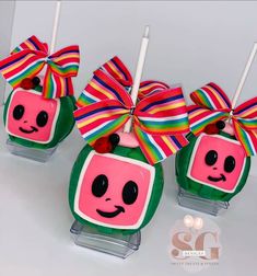 three lollipops with faces and bows on them