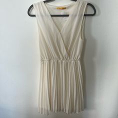 Cream Chiffon Pleated Dress By James Lacroix Purchased From Boutique In Lower Manhattan, Nyc V-Neck At Front With Snap At Bust Can Be Worn With Standard Bra Lined Ruffle In Front Along The Neckline Elastic Waist For Comfortable And Flattering Fit Measures Approximately 37” From Top Of Shoulder To Bottom Hem, 19” Flat Across Armpit-To-Armpit, 13” To 21” Flat Across Waist (Elastic) Excellent Condition, Nwt, Euc Has Been Stored In Smoke And Pet Free Home Closet Retail Us $118 Summer Pleated V-neck Chiffon Dress, Chic Pleated Chiffon Dress With V-neck, Chic Pleated V-neck Chiffon Dress, Pleated V-neck Chiffon Dress For Summer, Beach Pleated V-neck Mini Dress, Beach V-neck Pleated Mini Dress, Elegant V-neck Chiffon Dress For Day Out, White Sleeveless Chic Chiffon Dress, Fitted Sheer V-neck Chiffon Dress