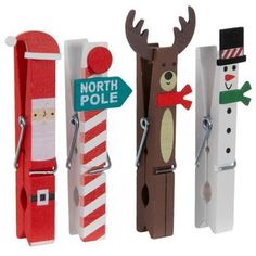 three wooden pegs with santa, snowman, and reindeer decorations attached to them