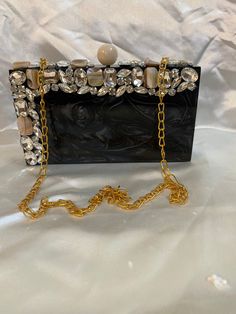 - Tich lock closure  - Golden chain inside - Removable sling chain This clutch can be worn as a shoulder bag with the sling chain or can simply be carried in hand.It is spacious enough to carry mobile phones, lipsticks, Keys and other small accessories.It comes in dust cover placed in a corrugated box. Designer Evening Bag With Pearl Handle, Designer Evening Bags With Pearl Handle, Luxury Evening Clutch With Pearl Handle, Formal Rectangular Evening Bag With Pearl Handle, Chic Pearl Embellished Evening Bag For Party, Elegant Clutch With Chain For Gift, Elegant Clutch With Chain Detail For Gifts, Elegant Clutch With Chain As A Gift, Luxury Evening Bag With Pearl Handle For Events