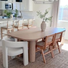 a dining room table with chairs and a potted plant on top of the table