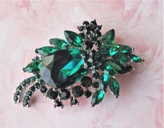 Elegant, Opulent and Shimmery.... This beautiful vintage inspired brooch is jeweled with cluster of Swarovski emerald green crystals. Pin is made of zinc metal and plated in silver. This elegant brooch is unique, feminine and eye-catching. Perfect for a bride that wants to make a statement or anyone to wear to a special occasion! It is also a thoughtful gift for Mother's Day, a birthday, wedding or anniversary. Cluster pin measures 2.75 x 1.5 inches. Green Rhinestone Wedding Brooch, Green Rhinestone Wedding Brooches, Elegant Green Rhinestone Brooches, Formal Green Rhinestone Brooches, Green Wedding Brooches, Elegant Brooch, Emerald Green Crystal, Floral Brooch, Wedding Vintage