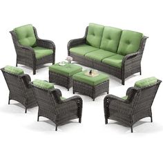 an outdoor furniture set with green cushions and matching chairs, coffee table and end tables