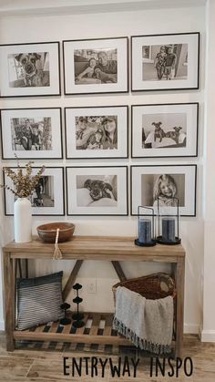 a wooden table with pictures on the wall above it