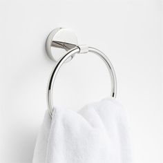 a towel hanging on the wall next to a toilet paper holder with a metal handle