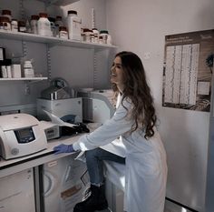 a woman sitting on top of a counter in a lab