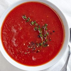 a white bowl filled with red soup on top of a table