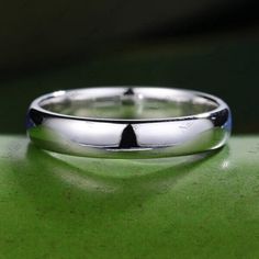 a wedding ring sitting on top of a green surface