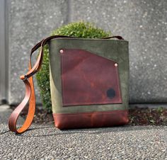 a brown and green bag sitting on the ground