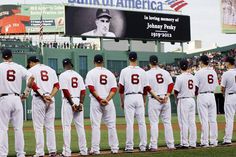 a group of baseball players standing on top of a field in front of a crowd