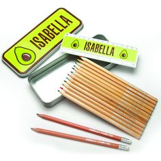 several pencils are in a tin with labels on the side and one has an avocado