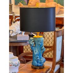 an elephant lamp sitting on top of a wooden table next to a blue and white vase