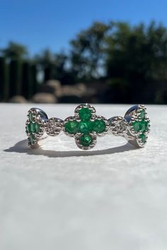 A timeless and elegant design, symbolizing wealth and harmony. Perfect for everyday wear or dressed up for special occasions. Make a bold statement in our Emerald and Diamond Clover Ring, handcrafted in 14k white gold. Item Specifications: Materials: 14k Solid White Gold  Gemstone: Natural Emeralds and Natural Diamonds Total Gold Weight: 2.22 ct. Total Diamond Carat Weight: 0.03 ct. Total Emerald Carat Weight: 0.34 ct. Emerald Diameter: 5.6 mm x 5.6 mm Diamond Clarity: SI 1-2 Diamond Color: G co Fine Jewelry Platinum Emerald Ring With Polished Finish, Fine Jewelry Emerald Ring In White Gold With Diamond, Luxury 14k White Gold Green Diamond Ring, Luxury Open Band Gemstone Jewelry, Luxury Green Diamond Ring In 14k White Gold, Elegant Platinum Emerald Ring With Polished Finish, Luxury Sterling Silver Polished Emerald Ring, Luxury 14k White Gold Green Jewelry, Luxury Emerald Ring In White Gold With Polished Finish