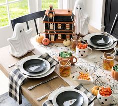 a table set for halloween with ghost decorations