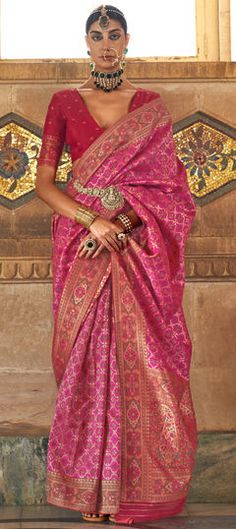 a woman in a pink and gold sari