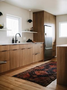 a kitchen with wooden cabinets and an area rug