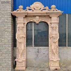 an old building with statues on the front and side of it, next to a blue wall