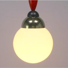 a white and black light hanging from a ceiling fixture with a red cord attached to it