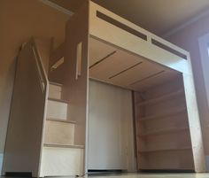 an unfinished loft bed with stairs leading up to it