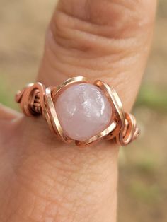 Rose quartz ring. Size 9. Wrapped in copper.  Can be oxidized upon request. Just let me know at checkout.  The pink vibration of rose quartz activates the bridge between the upper three chakras and the lower three. This significant because this bridge helps connect your human existence as a grounded individual on this planet with your spiritual one. This stone aligns your consciousness with Divine love, compassion, mercy, tolerance and kindness. It calls the energy of the angels to surround and protect you. Rose quartz encourages you to be gentle but firm. There is no question of pliability or giving in, rather there is an awareness of the gentle soft nature overcoming the, hard strong one. Rose quartz encourages helpfulness, openness and the desire for pleasant ambience. Rose Quartz is on Wire Wrapped Rose, Human Existence, Ring Wire, Malachite Rings, Peridot Jewelry, Divine Love, Malachite Jewelry, Handmade Rose, One Rose