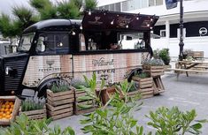 an old food truck is parked on the side of the road with crates full of oranges